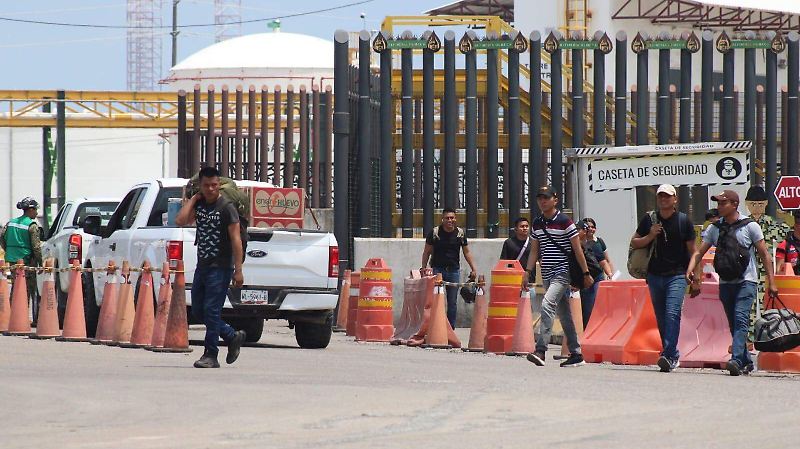 Grupo-De-Pesonas-Pasan-Por-La-Refinería